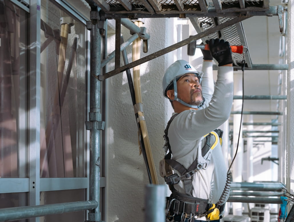 職人が外壁に塗装を行っている作業現場の写真