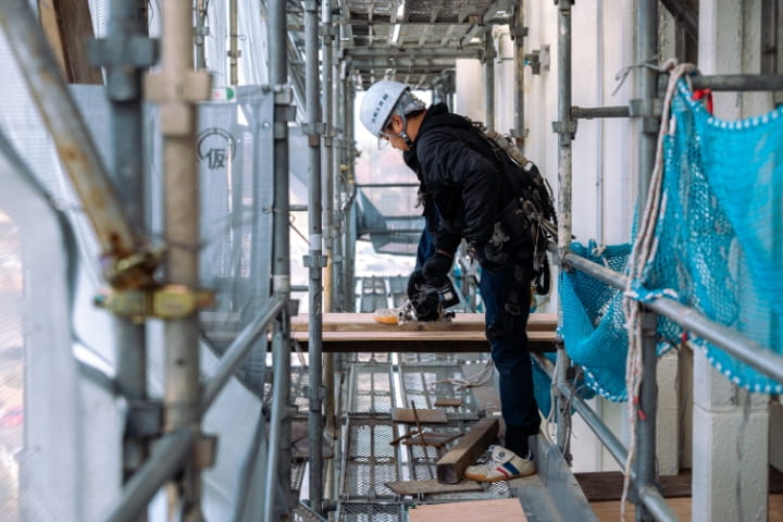 ローラーで壁面を塗装している作業写真